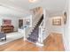 Spacious foyer with hardwood floors, carpeted stairs, and a view into the living room at 5061 S Florence Dr, Englewood, CO 80111