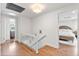 Bright hallway with hardwood floors leading to a bedroom featuring a wicker bed frame at 5061 S Florence Dr, Englewood, CO 80111