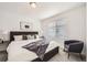 Bright bedroom featuring a gray upholstered bed, soft textiles, and a cozy chair at 348 N. Geneva St, Aurora, CO 80010