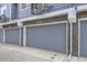 Close-up of gray garages with unit numbers, set against the backdrop of the building at 348 N. Geneva St, Aurora, CO 80010
