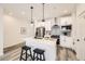 Stylish kitchen featuring a quartz island with barstools, stainless appliances, and modern pendant lighting at 348 N. Geneva St, Aurora, CO 80010