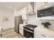 Well-lit kitchen featuring stainless steel appliances, white cabinets, and a stylish backsplash, offering a functional and inviting space at 348 N. Geneva St, Aurora, CO 80010