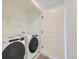 Modern laundry room with front load washer and dryer and white shelving at 348 N. Geneva St, Aurora, CO 80010