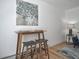 Dining area with wooden table, stools, and tree-themed painting against a white wall at 1629 N Clarkson St # 13, Denver, CO 80218