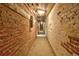 Basement hallway with exposed brick walls and concrete flooring at 1629 N Clarkson St # 13, Denver, CO 80218