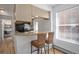 Open-concept kitchen featuring breakfast bar, wood floors, and view to dining area at 1629 N Clarkson St # 13, Denver, CO 80218