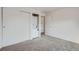 Bedroom featuring carpet, closet, stacked washer and dryer unit, and doorway at 7165 S Gaylord St # E07, Centennial, CO 80122