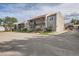 View of a two-story condominium building with muted gray exterior and black iron stairs to upper-level units at 7165 S Gaylord St # E07, Centennial, CO 80122