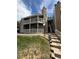 Condominium exterior featuring a stone chimney, balconies, and well-maintained landscaping at 921 S Walden Street # 205, Aurora, CO 80017