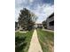 Landscaped exterior view along sidewalk, showing the community's well-manicured green spaces and buildings at 921 S Walden Street # 205, Aurora, CO 80017