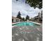 Community swimming pool with lounge area, and surrounding residential buildings and mature trees at 921 S Walden Street # 205, Aurora, CO 80017