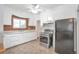 Charming kitchen featuring white cabinets, modern appliances, and unique brick accent wall at 6900 E 66Th Ave, Commerce City, CO 80022