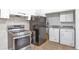 Functional kitchen featuring white cabinets, stainless steel appliances, and a laundry area at 6900 E 66Th Ave, Commerce City, CO 80022