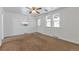 Bright living room featuring a ceiling fan, neutral walls, and large windows providing natural light at 6900 E 66Th Ave, Commerce City, CO 80022