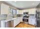 Modern kitchen with white cabinets, stainless steel appliances, and granite countertops at 9916 Spring Hill Ln, Highlands Ranch, CO 80129