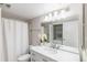 Well-lit bathroom featuring a marble countertop, brushed nickel fixtures, and a convenient, in-unit washer and dryer at 2525 S Dayton Way # 1109, Denver, CO 80231