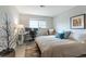 Bright bedroom with a desk, chair, bed, and large window providing natural light at 12406 E Pacific Cir # D, Aurora, CO 80014
