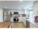 Well-lit kitchen featuring white cabinets, granite countertops, and stainless steel appliances at 12406 E Pacific Cir # D, Aurora, CO 80014