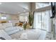 Bright living room featuring a fireplace, light hardwood floors, large window, and access to dining area at 12406 E Pacific Cir # D, Aurora, CO 80014