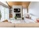 Bright living room with a stone fireplace, wood ceiling, and a comfortable white sofa at 12406 E Pacific Cir # D, Aurora, CO 80014