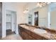 Bathroom with double sinks, large mirror, granite countertops, and walk-in closet at 4625 Walden Ct, Denver, CO 80249
