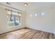Bright bedroom with large window, tray ceiling, and wood floor at 4625 Walden Ct, Denver, CO 80249