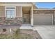 Welcoming front entrance featuring stone accents, and a two-car garage, providing ample parking space at 4625 Walden Ct, Denver, CO 80249
