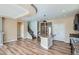 Open-concept living room features wood floors, stairs, island with granite countertop, and stainless steel refrigerator at 4625 Walden Ct, Denver, CO 80249