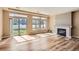 Bright open-concept living room with hardwood floors, fireplace, and sliding glass doors at 4625 Walden Ct, Denver, CO 80249