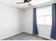 This bedroom features neutral walls, plush gray carpet, a ceiling fan, and a window with blue curtains at 7811 E 123Rd Ave, Thornton, CO 80602