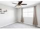 This bedroom has a ceiling fan and natural light from the window with neutral curtains and a shelf on the wall at 7811 E 123Rd Ave, Thornton, CO 80602