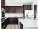Modern kitchen with stainless steel appliances, white countertops, and dark wood cabinetry at 7811 E 123Rd Ave, Thornton, CO 80602