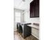 This laundry room features updated appliances, tile floors, overhead lighting, and built-in storage and counter space at 7811 E 123Rd Ave, Thornton, CO 80602
