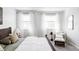 Bright main bedroom featuring a cozy sitting area and a plush bed with neutral tones at 7811 E 123Rd Ave, Thornton, CO 80602
