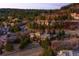 An aerial view of a stunning stone home with wooded surroundings and a long driveway at 1042 Country Club Estates Dr, Castle Rock, CO 80108