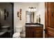 A bathroom featuring a dark marble shower, dark wood cabinets and animal-themed decorations at 1042 Country Club Estates Dr, Castle Rock, CO 80108