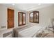 A serene bedroom featuring arched windows, plantation shutters and neutral decor at 1042 Country Club Estates Dr, Castle Rock, CO 80108