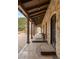 Covered stone walkway featuring timber beams and arched doorways provides elegant access to the home at 1042 Country Club Estates Dr, Castle Rock, CO 80108