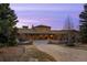 Majestic stone estate featuring an arched entryway and grand facade set against a colorful evening sky at 1042 Country Club Estates Dr, Castle Rock, CO 80108
