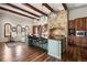 Stylish kitchen with exposed beams, island seating, and stone accents with hardwood floors at 1042 Country Club Estates Dr, Castle Rock, CO 80108