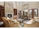 Inviting living room featuring a soaring stone fireplace, high ceilings, and abundant natural light at 1042 Country Club Estates Dr, Castle Rock, CO 80108