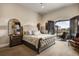 Spacious main bedroom suite with a luxurious upholstered headboard, arched entry to balcony, and sitting area at 1042 Country Club Estates Dr, Castle Rock, CO 80108