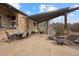 Expansive stone patio features a dining area, lounge area, and sun loungers beneath a modern pergola at 1042 Country Club Estates Dr, Castle Rock, CO 80108