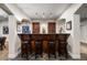 Charming wet bar features stone flooring, wooden cabinetry, and comfortable seating, perfect for casual gatherings at 1042 Country Club Estates Dr, Castle Rock, CO 80108