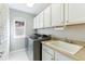 A functional laundry room with a sink, cabinets, window, and modern washer and dryer at 18130 Bolero Dr, Parker, CO 80134