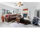 Comfortable living room with a brick fireplace, plush sofa, and ample natural light from the window at 18130 Bolero Dr, Parker, CO 80134