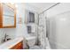Bright bathroom features a vanity with a wood cabinet, a mirror, and a shower with a curtain at 518 Cherry St, Hudson, CO 80642