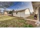 Backyard view of a detached one car garage with a white door and light yellow siding at 518 Cherry St, Hudson, CO 80642
