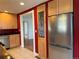 Kitchen with stainless steel refrigerator, tile floors, wood cabinets, and a bi-fold door at 5618 Carr St, Arvada, CO 80002