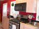Cozy kitchen showcasing stainless steel appliances, maple cabinets, black granite countertops, and a bright red wall at 5618 Carr St, Arvada, CO 80002